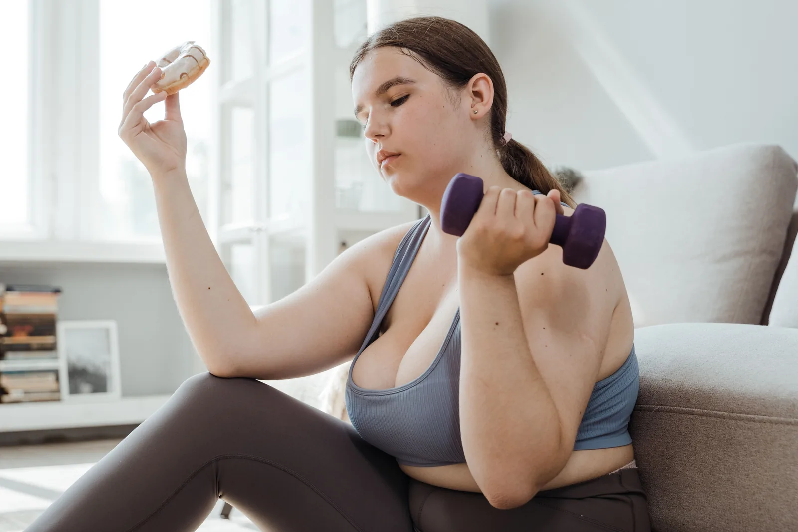 Holding a dumbbell in one hand and a pastry in the other